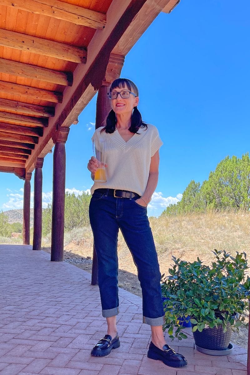 Catherine Brock wearing boyfriend jeans, sweater vest, and chunky loafers.