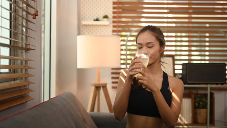 Sporty woman drinks collagen supplement.