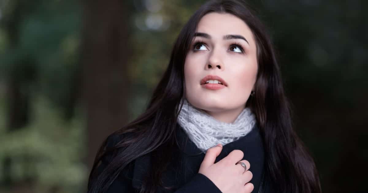 Close up of woman wearing makeup, looking up.