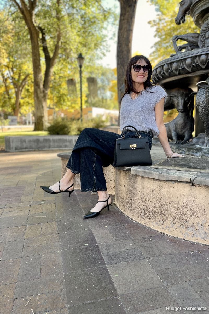 Levantine Layla bag on curb next to stylish woman sitting outside.