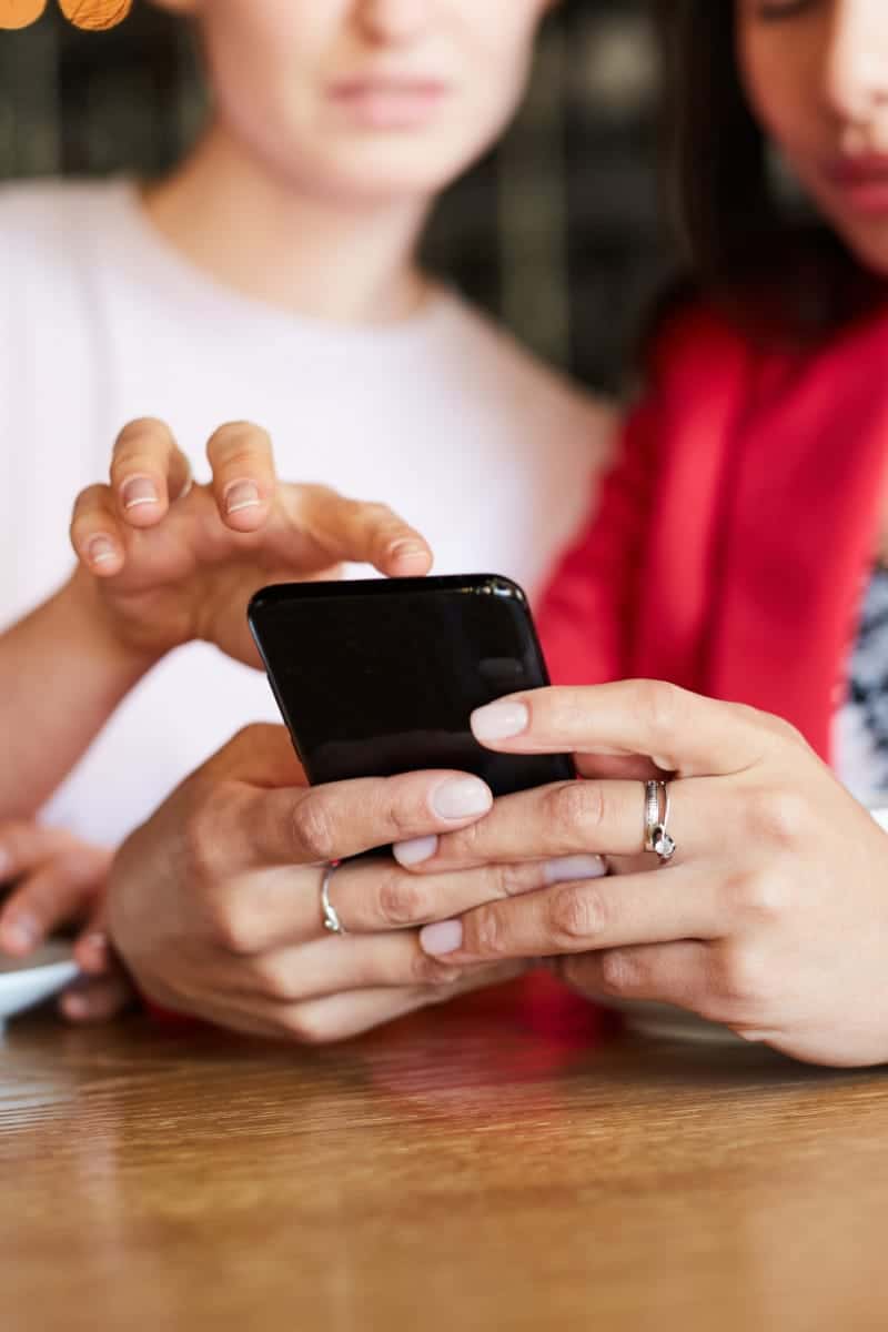 Two women shop Amazon Prime Day deals on a smartphone.