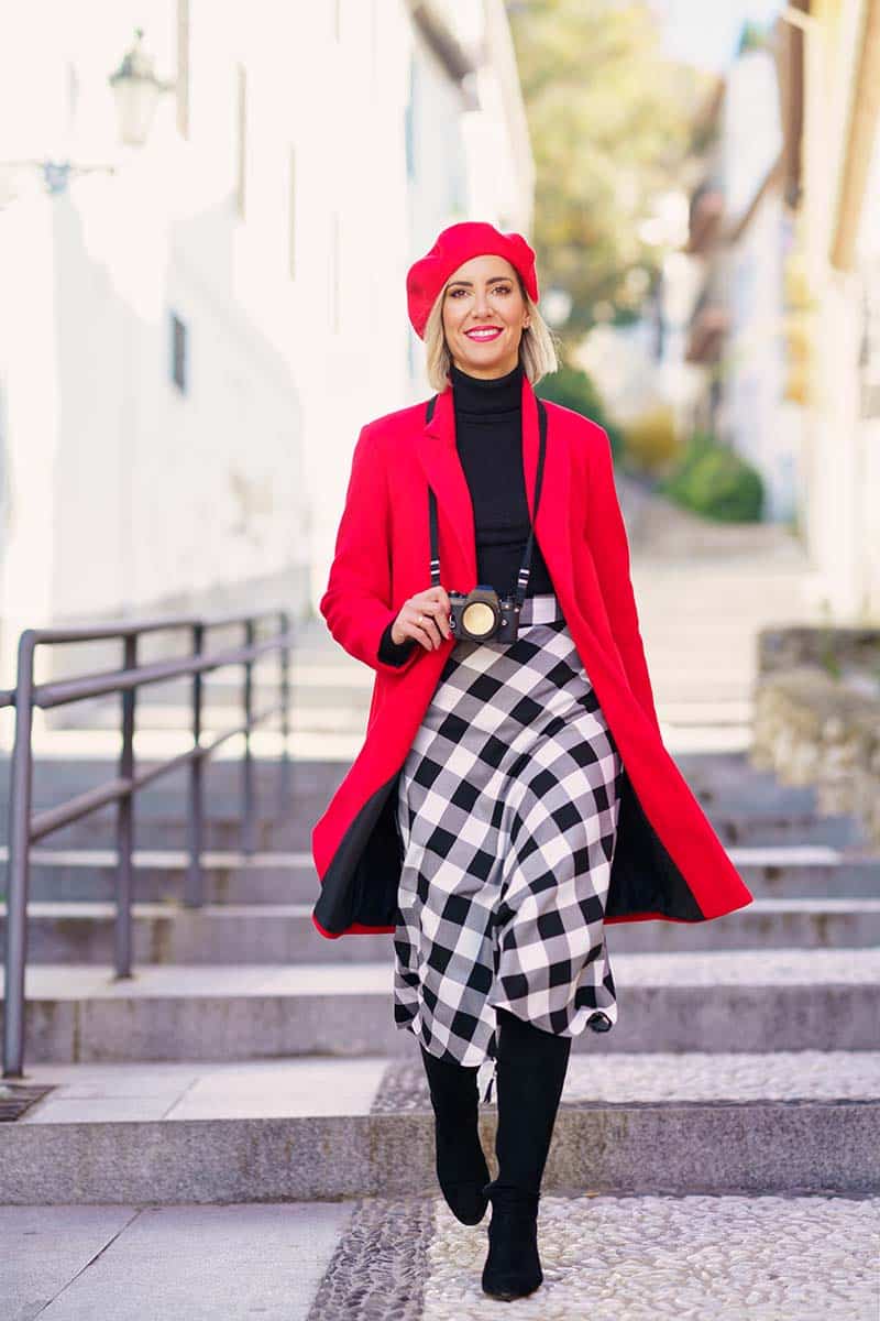 What Is My Style? 25 Personalities & the Styles They Love 3 Woman wearing bold outfit with red beret and jacket walks outside.