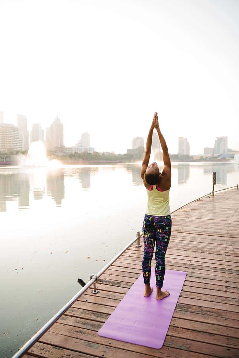 Woman doing yoga at park to represent working out.