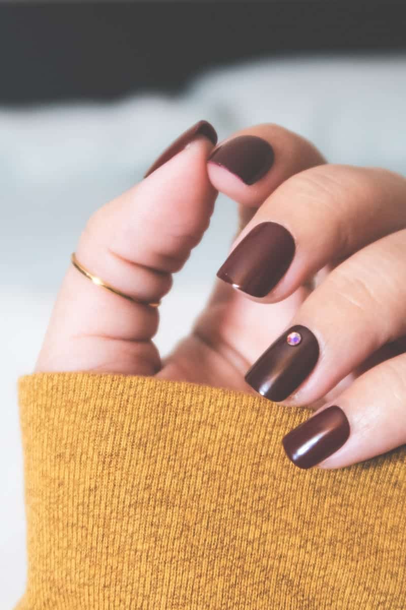 6 Gel Nail Alternatives for Your Best Manicure 2 Close-up view of woman wearing red press-on nails.