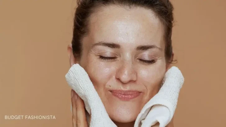 Woman holding washcloths against her face.