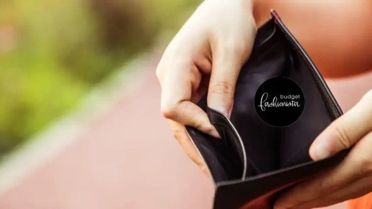Person holding open an empty wallet outside.