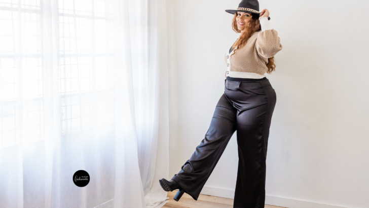 Woman in hat, sweater, and black wide-leg pants.