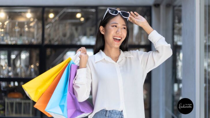 Happy woman holding colorful shopping bags.