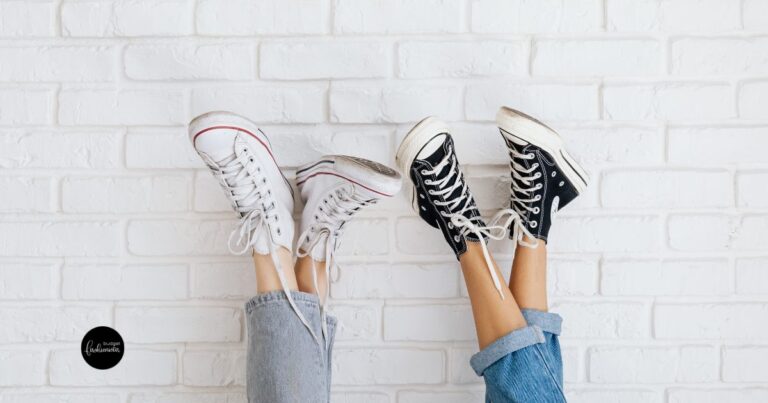 Legs in jeans wearing black and white sneakers