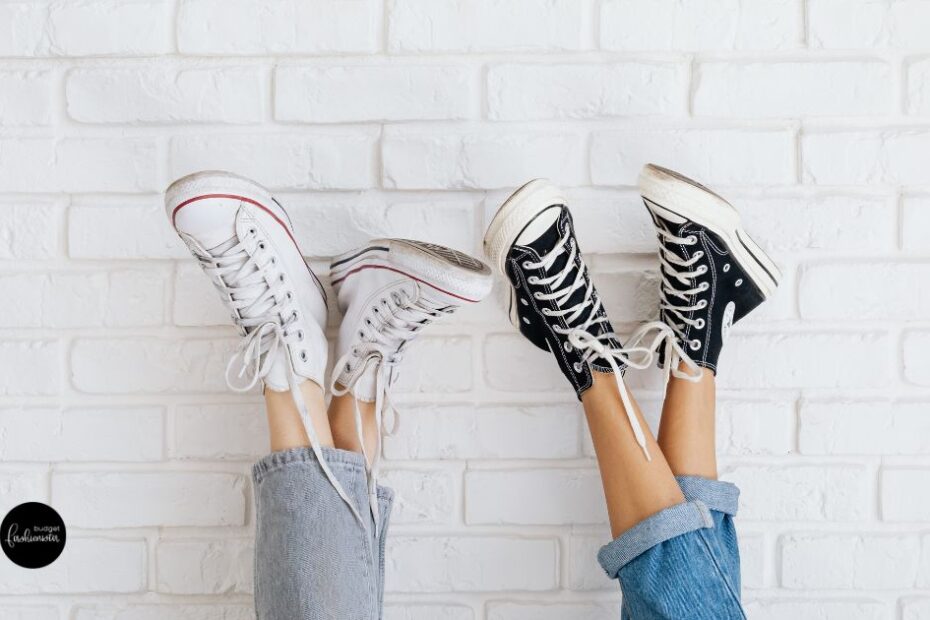 Legs in jeans wearing black and white sneakers