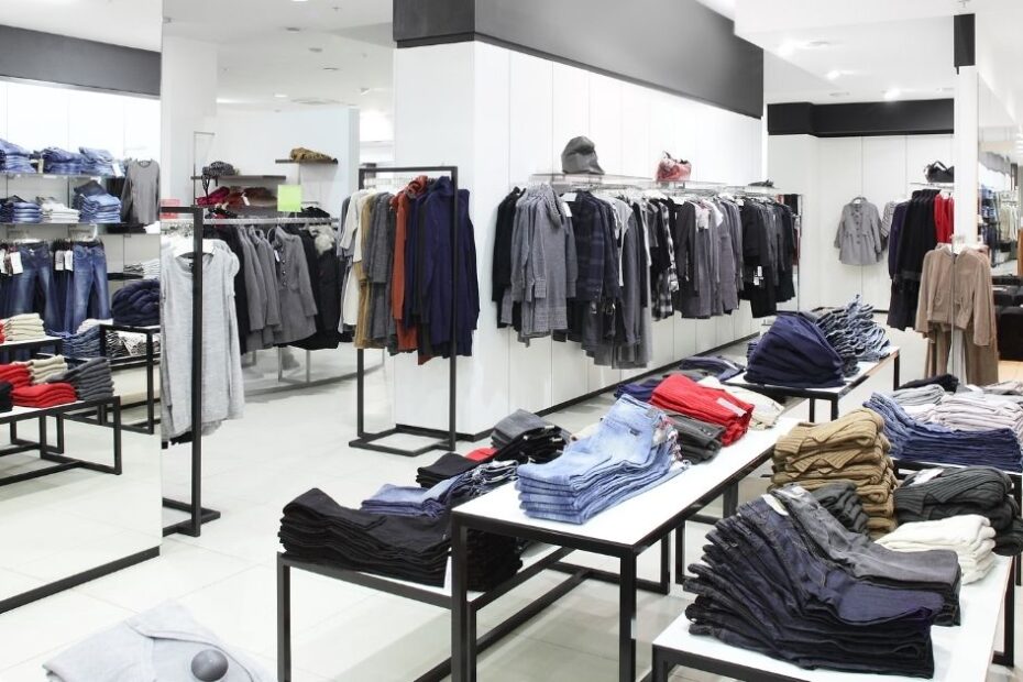 Modern clothing store with folded jeans and tops on tables