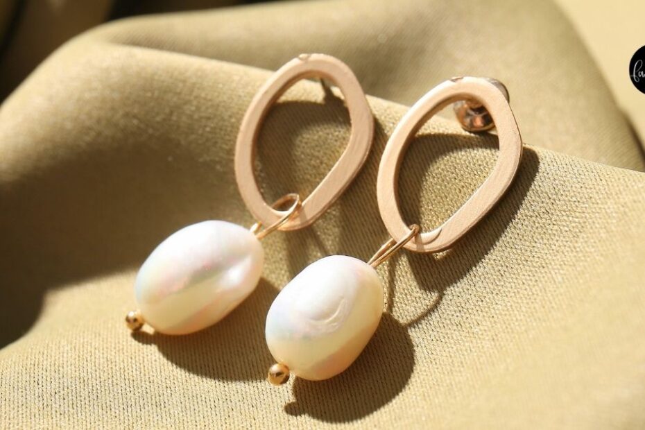 Pearl earrings on green textile