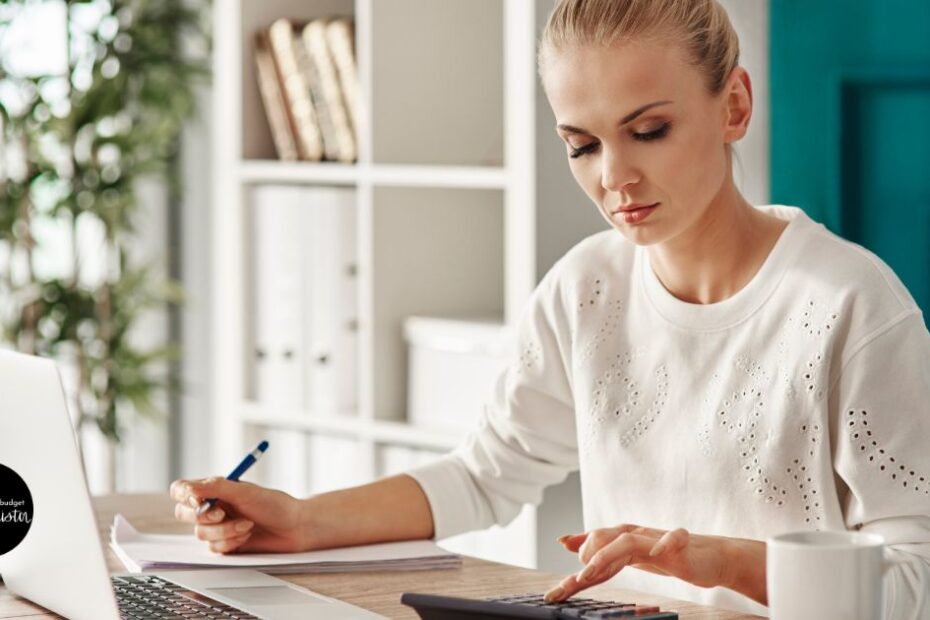 Woman uses calculator to budget for a debt refinance