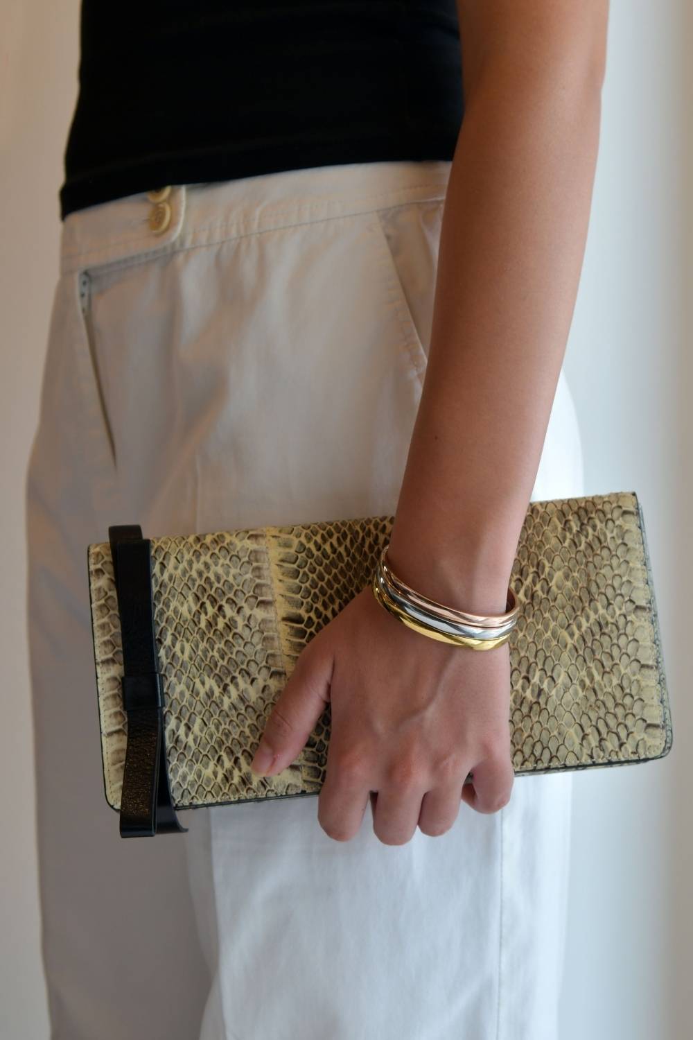 Bag rut? 7 handbags that work as hard as your go-to crossbody 7 close up of snakeskin clutch wristlet bag